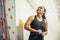 Young woman with chalked hands posing at indoor climbing gym wall