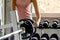 Young woman changing weight on dumbbell in gym