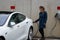 Young woman charges electric car