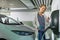 Young woman charging an electric vehicle in an underground garage