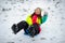 The young woman cheerfully moves down from a hill on the saucer sled.