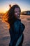 Young woman cheerfully on a sunset at the beach