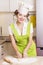 Young Woman chef in chef hat cooking dough in kitchen