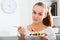 Young woman with chestnut hair eating salad