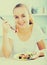 Young woman with chestnut hair eating salad