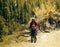 Young woman with children on mountain trail on flowering apricots