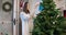 Young woman with children prepares Christmas tree for winter holidays