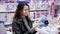 Young woman choose a toy doll in a children`s store for my daughter