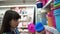 A young woman chooses and buys plastic baskets for things in the supermarket.