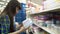 A young woman chooses and buys a plastic container for food in the supermarket.