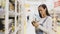 Young woman is chooses canned mushrooms in glass jar at supermarket.