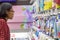 A young woman chooses cosmetics at a store.