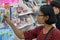 A young woman chooses cosmetics at a store.