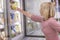 Young woman chooses frozen food in the fridge of a supermarket. Close-up