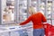 Young woman chooses frozen food in a supermarket