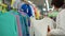 A young woman chooses a knitted cardigan for the child in a supermarket.