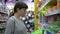 A young woman chooses a plastic lunch box in the supermarket.