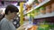 A young woman chooses a plastic lunch box in the supermarket.