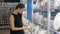 Young woman chooses plates in shop cookware, dish choosing by elegant girl in supermarket