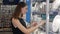 Young woman chooses plates in shop cookware, dish choosing by elegant girl in supermarket