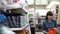 A young woman chooses a small orange container in a building supermarket.