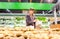 Young woman choosing fresh potatoes at shopping in supermarket