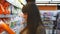 Young woman choosing household chemicals in supermarket. Beautiful girl selects fabric softener or washing powder at the