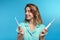 Young woman choosing between manual and electric toothbrushes