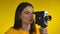 Young woman cinematographer is using a retro camcorder for shooting video