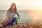 A young woman on a clean-up coastal area. Sea and sky in the background. Earth day and ecology. Copy space. Light