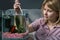 Young woman cleaning aquarium with beta fish at home.