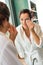 Young woman cleaning face cotton pads bathrobe