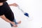 Young woman cleaning floor with modern steam cleaner. Isolated image on white