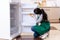 The young woman cleaning fridge in hygiene concept