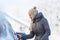 Young woman cleaning her car from snow and frost