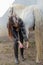 Young woman cleaning her horse`s hooves