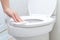 Young woman cleaning Toilet seat by a wet wipe in public restroom