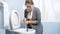 Young woman cleaning toilet and trying to get rid off bad smell