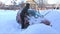 Young woman cleans snow from car