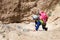 Young woman climbing desert canyon cliff.
