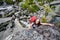 Young woman is climbing at stone whike trekking in highlands of