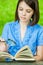 Young woman close-up reading book magnifier