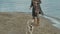 Young woman in a coat with a girl with curly hair, mom and daughter, run, play with a brown dog on the beach, brood her