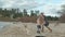 Young woman in a coat with a girl with curly hair, mom and daughter, run, play with a brown dog on the beach, brood her