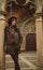 Young woman with coat and hat leaning on the column in a cathedral in Olite Navarra Spain