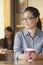 Young woman at coffee shop looking away in contemplation