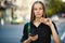 Young woman with coin bitcoin and smartphone in hand on the back