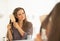 Young woman combing hair in bathroom