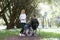 Young woman communicates with man in wheelchair in park