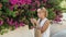 Young woman compares a color of lipstick with flower